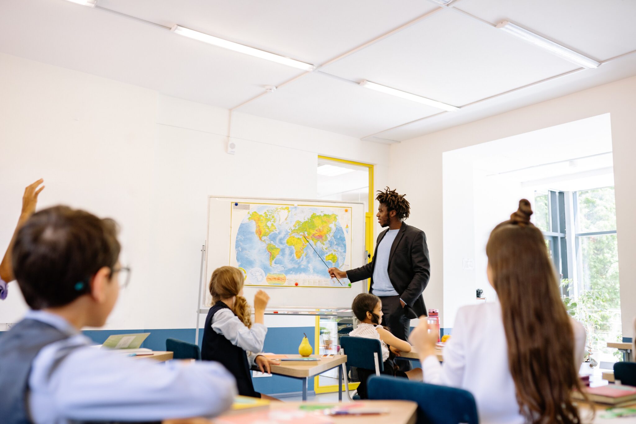 Male teacher leading students in a classroom