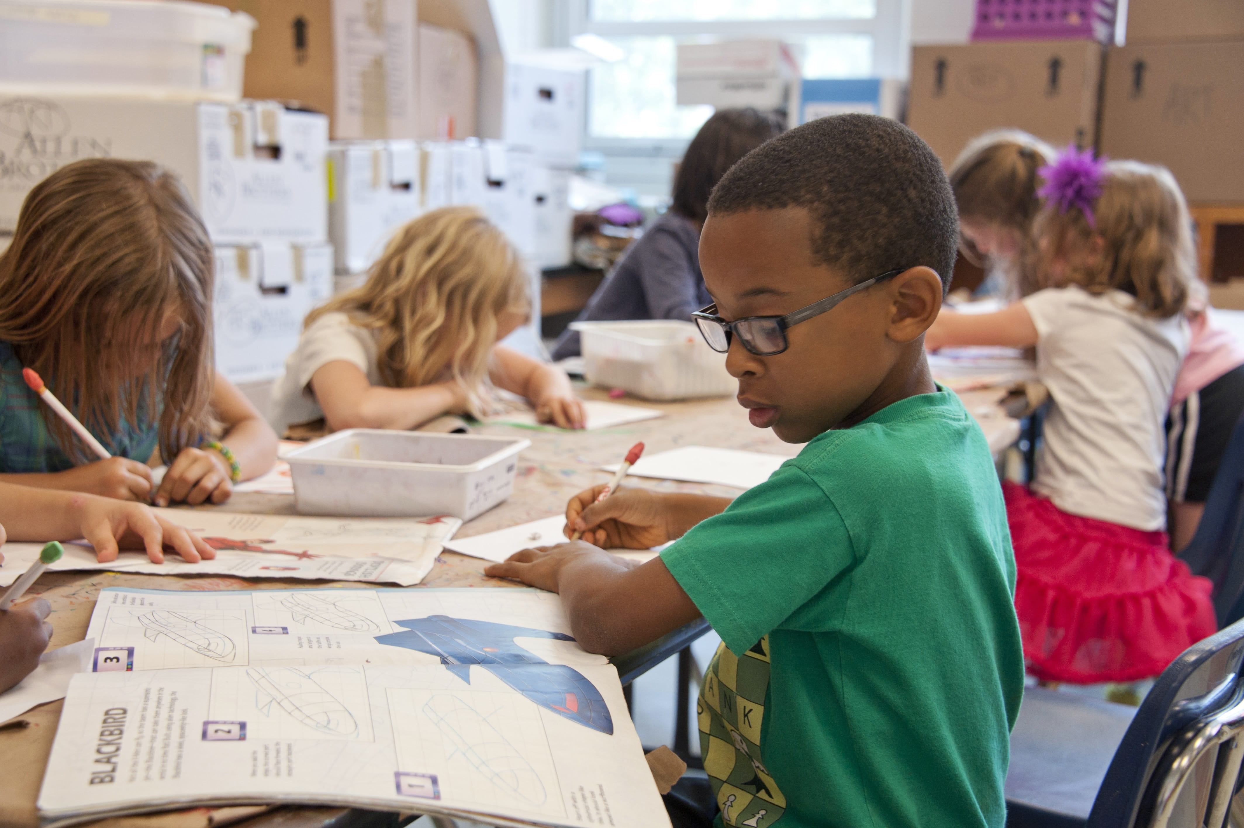 Elementary scholar completing classwork at a desk
