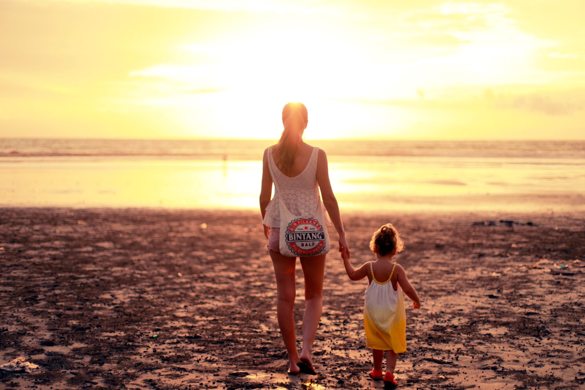 Parent and child walking together at sunset