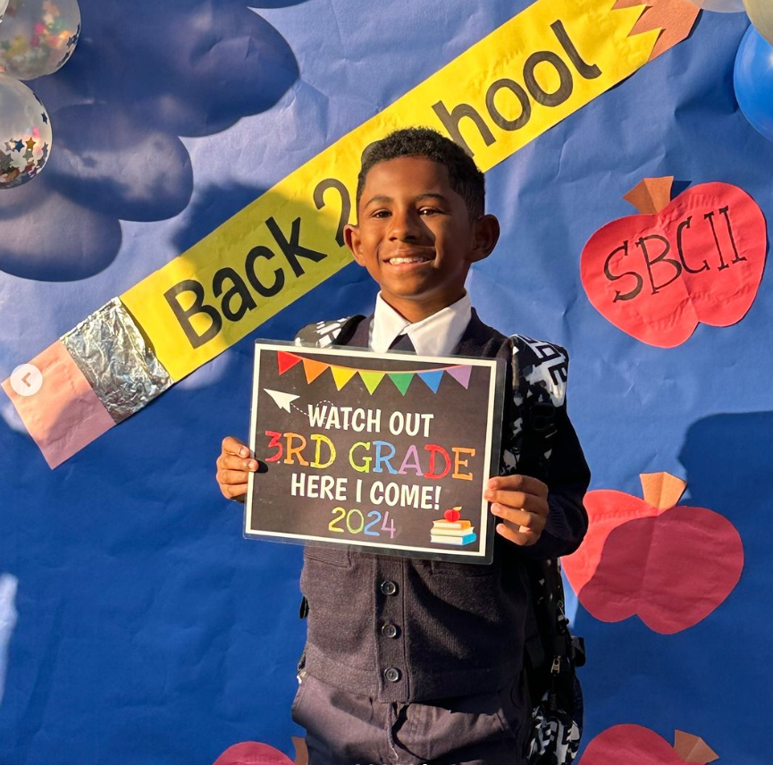 Scholar holding a back-to-school sign for third grade