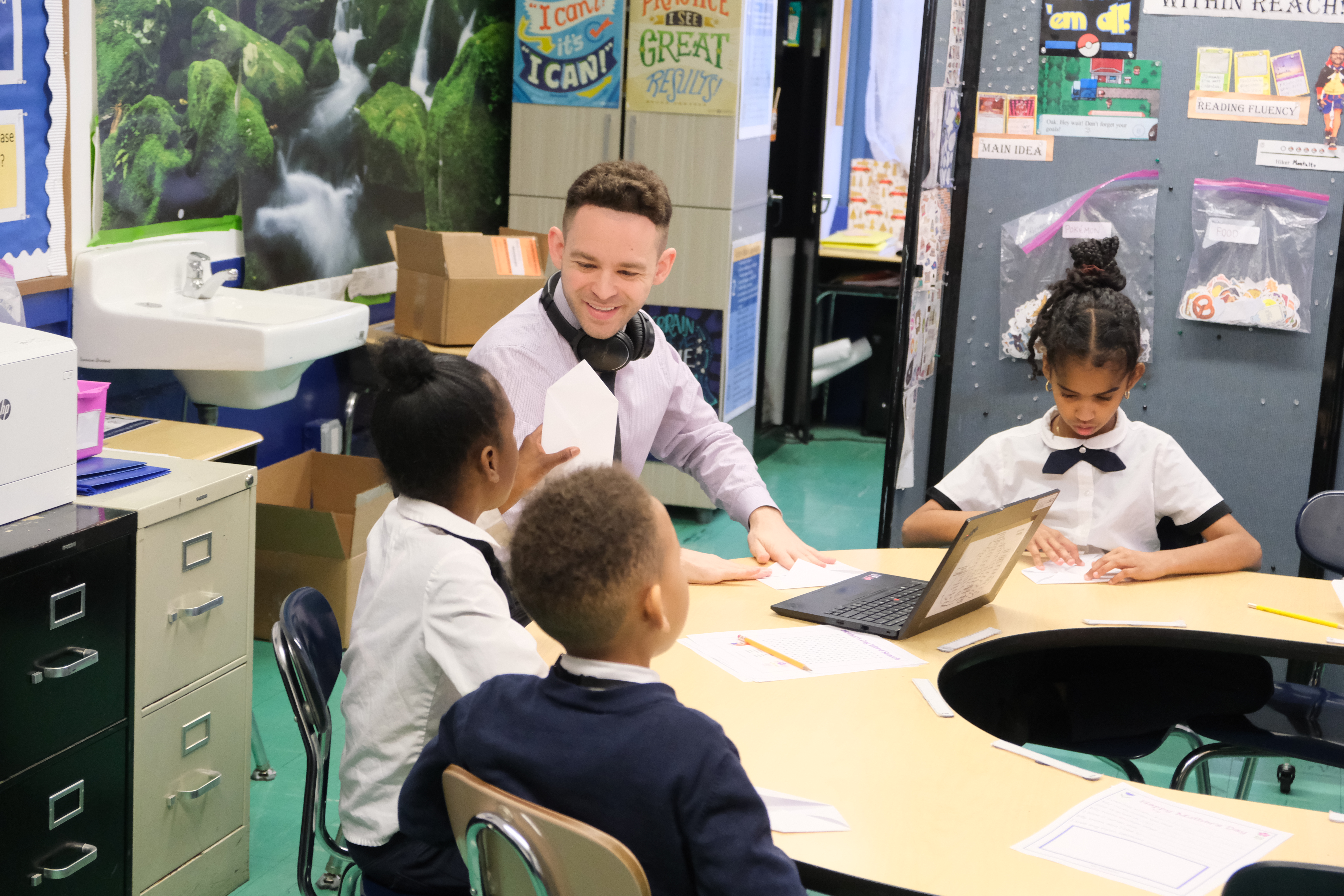 Teacher supporting scholars in a small-group lesson