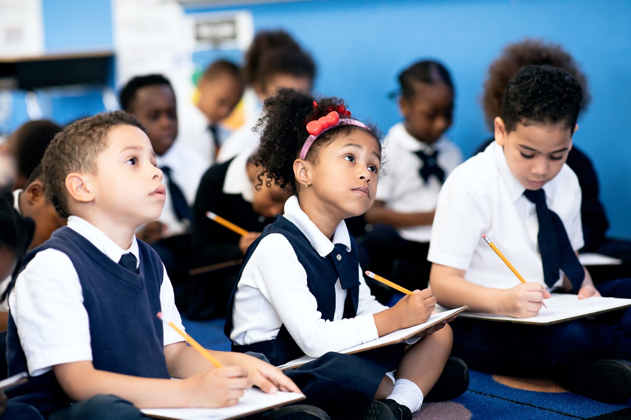 Elementary scholars participating in classroom instruction