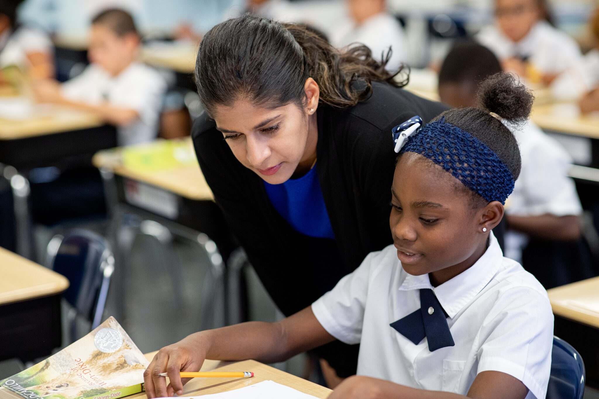 Teacher helping a scholar with classroom work