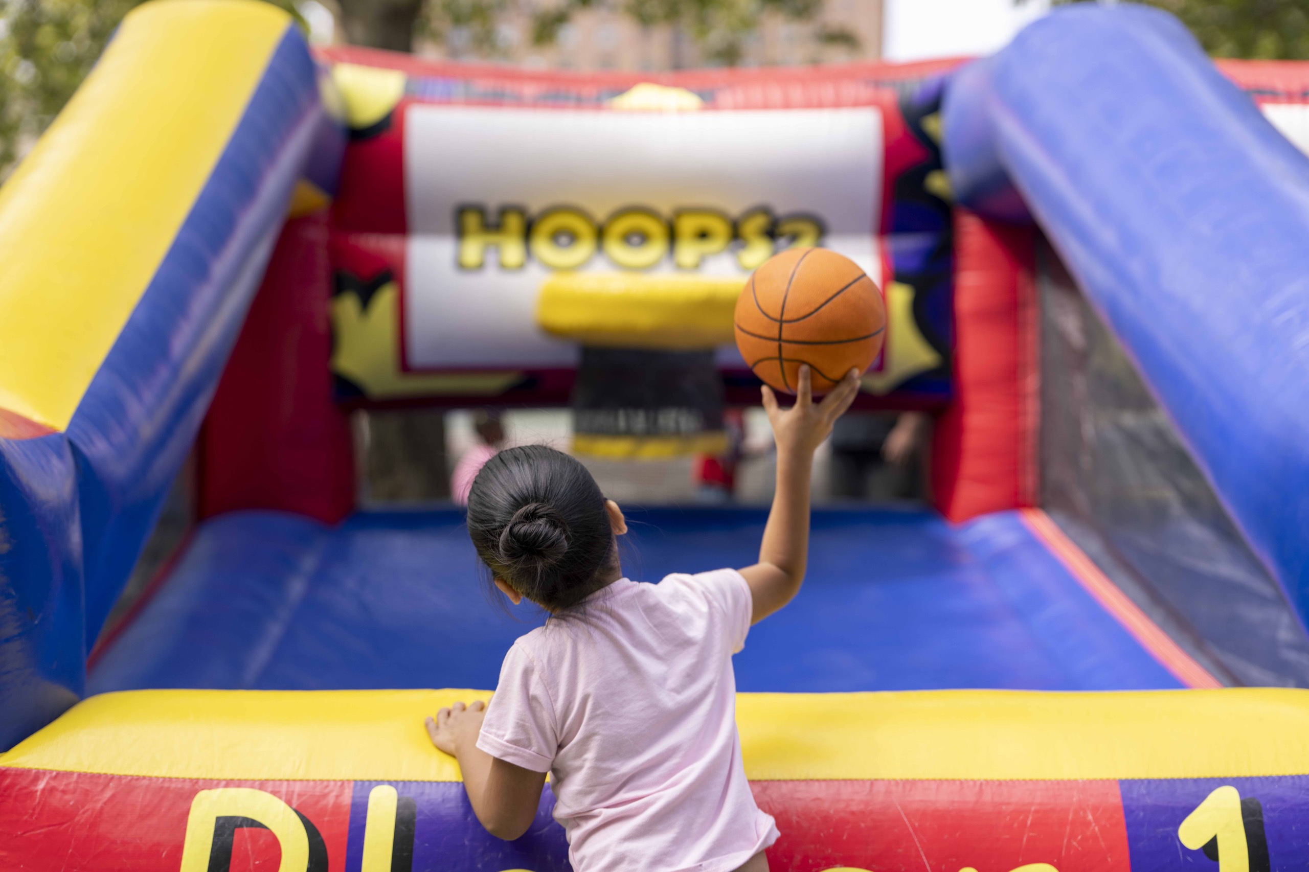 A young guest takes a shot at the hoops game