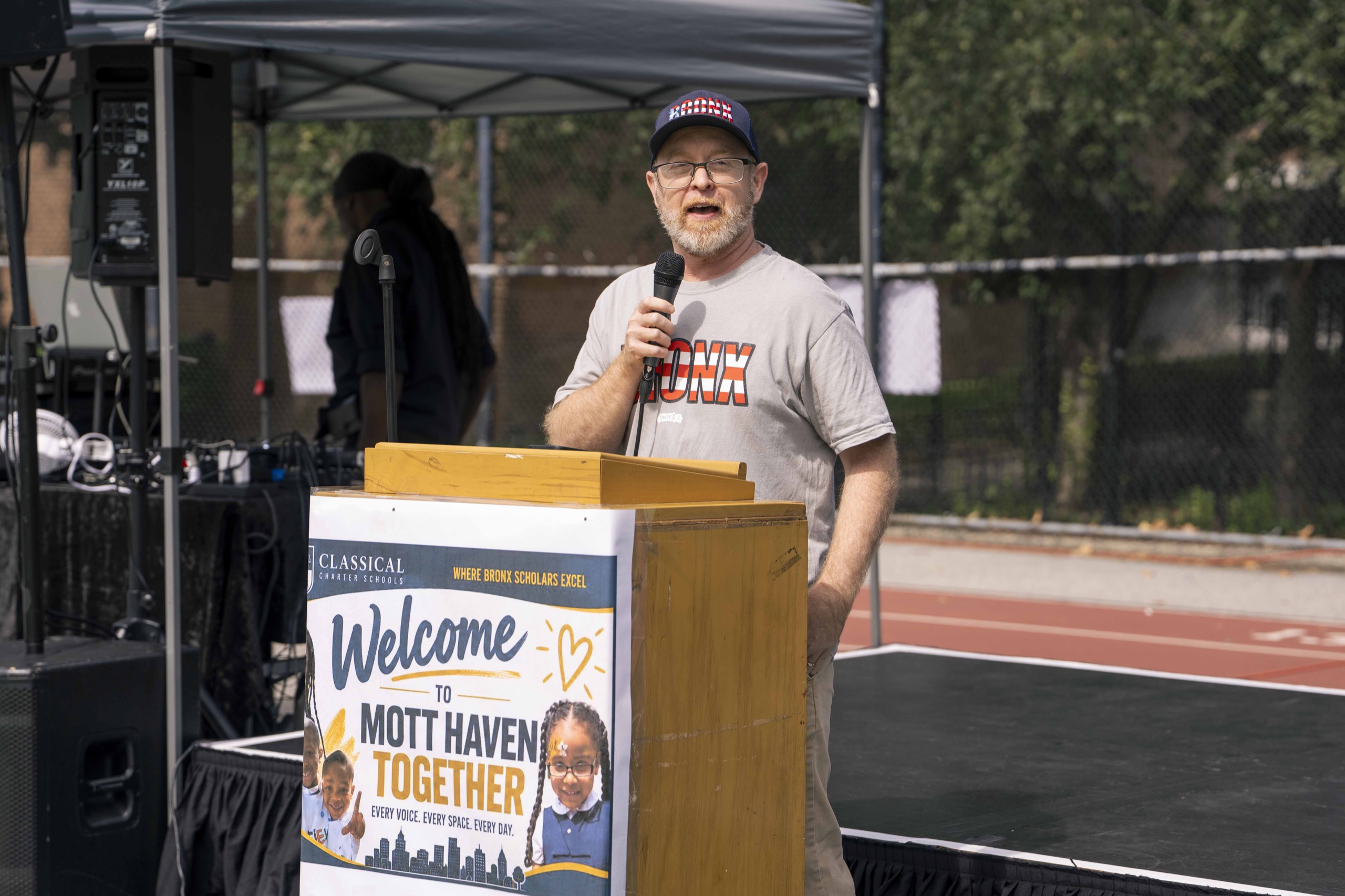 A speaker welcomes the Mott Haven Together community