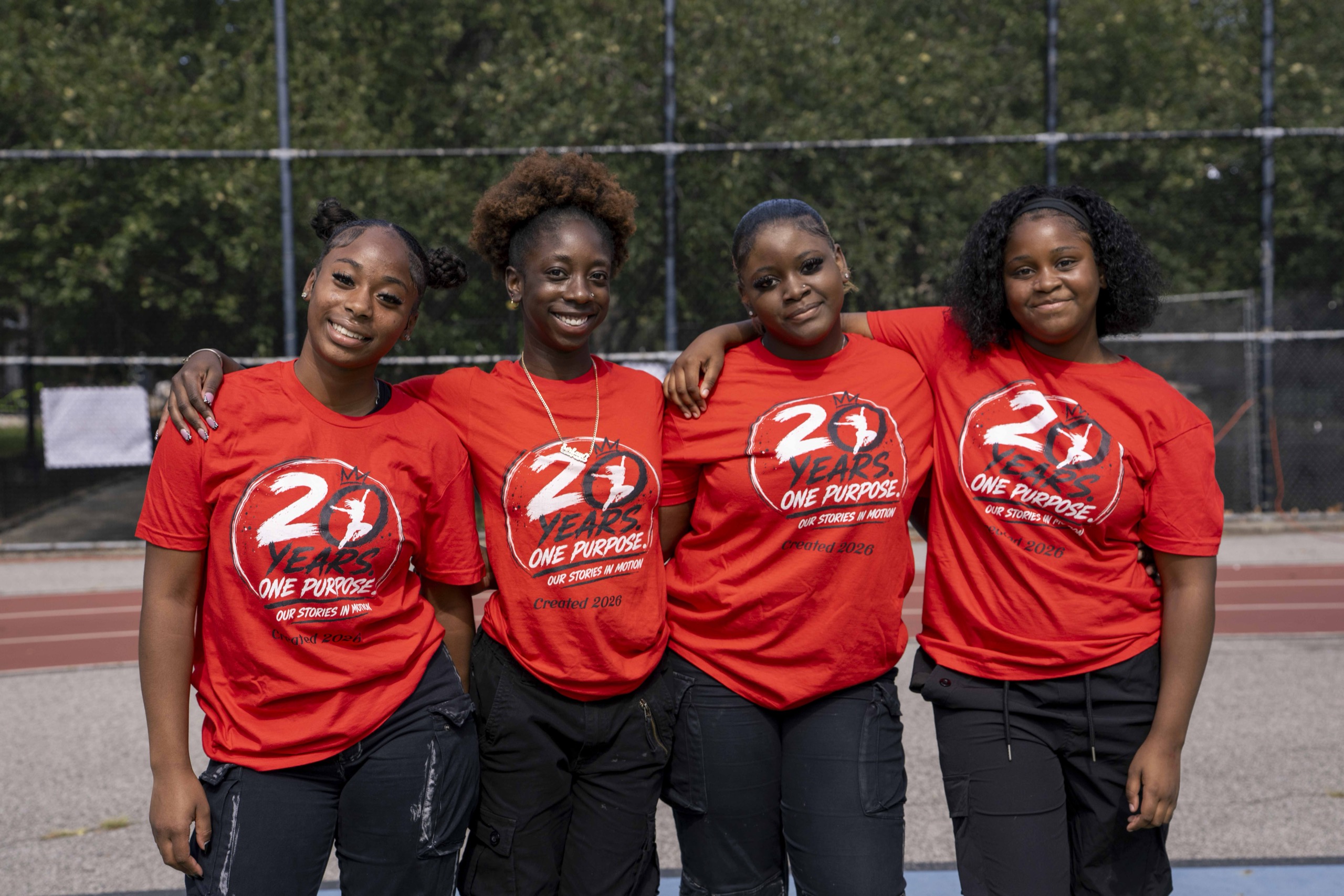 Four young performers wearing red event shirts