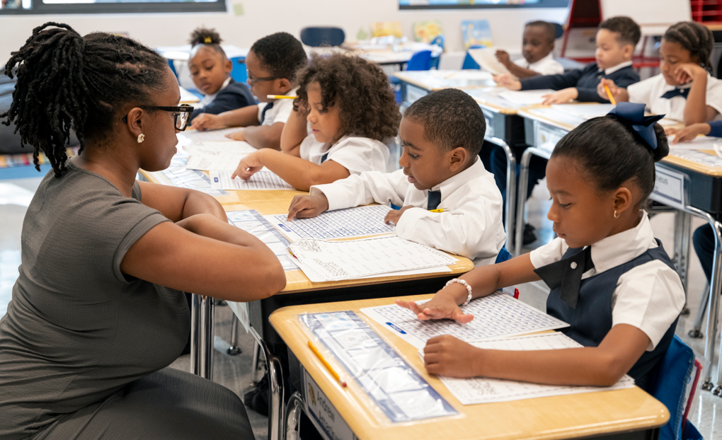Teacher working with Classical scholars as they complete written classroom activities
