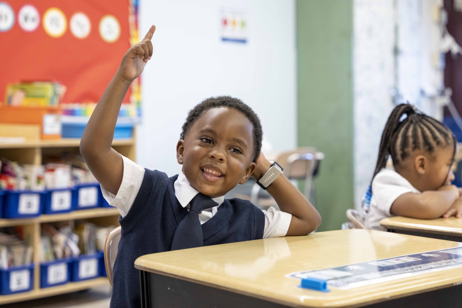 A Classical scholar raises a hand during a classroom lesson.