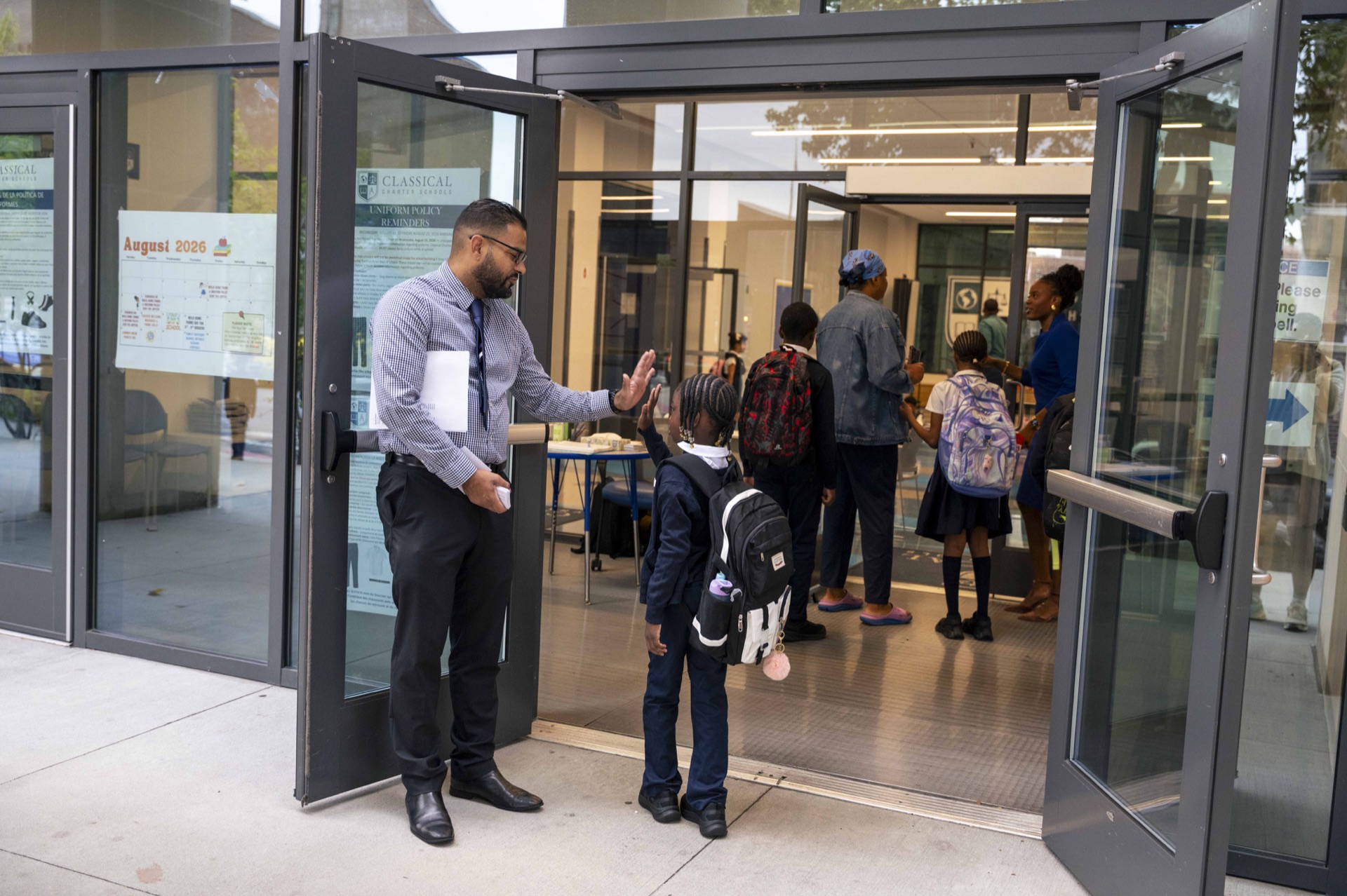 A Classical staff member greets a scholar with a high five.